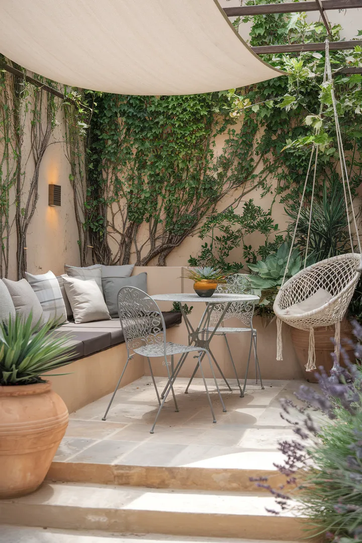 Eine gemütliche Gartensitzecke mit überdachter Lounge, Kletterpflanzen an der Wand und einer Hängeschaukel für entspannte Stunden im Grünen.