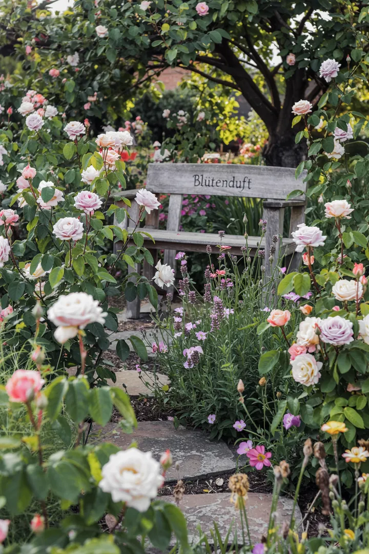 Ein blühendes Arrangement aus zarten Blüten in verschiedenen Farben, das harmonisch in einem Garten angeordnet ist. Ein elegantes Zusammenspiel von duftenden Pflanzen, das einladende Atmosphäre schafft und die Sinne betört.