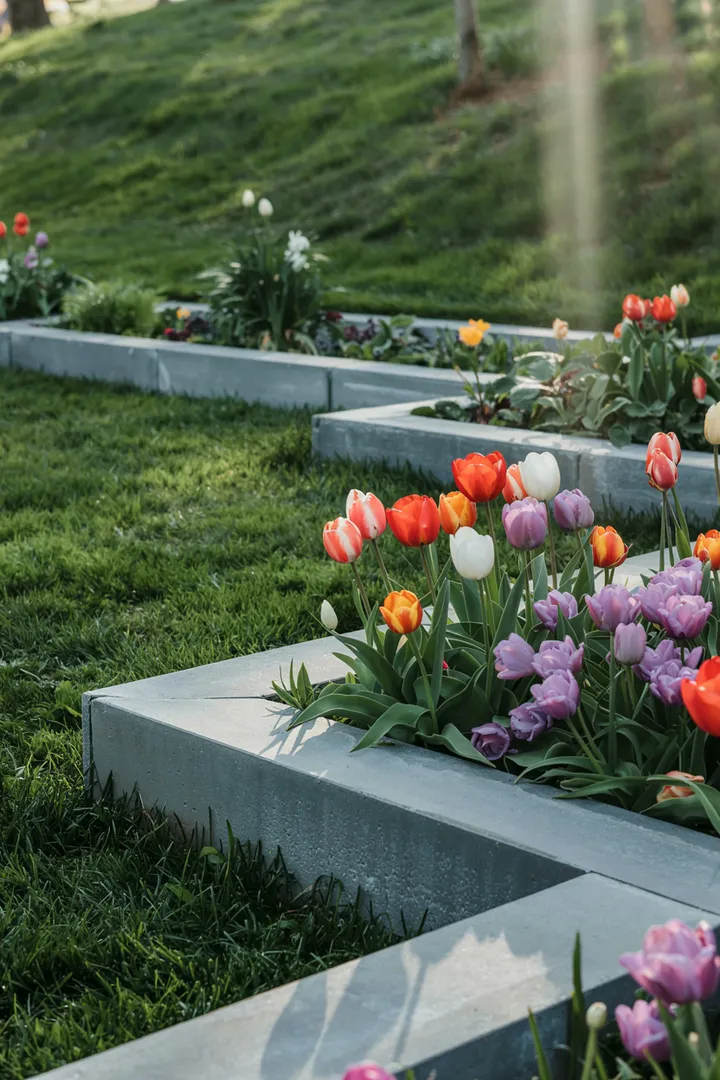 Ein wunderschöner Außenbereich mit farbenfrohen Pflanzen, umgeben von stabilen, dekorativen Steinen, die eine harmonische Grenze im Garten schaffen.
