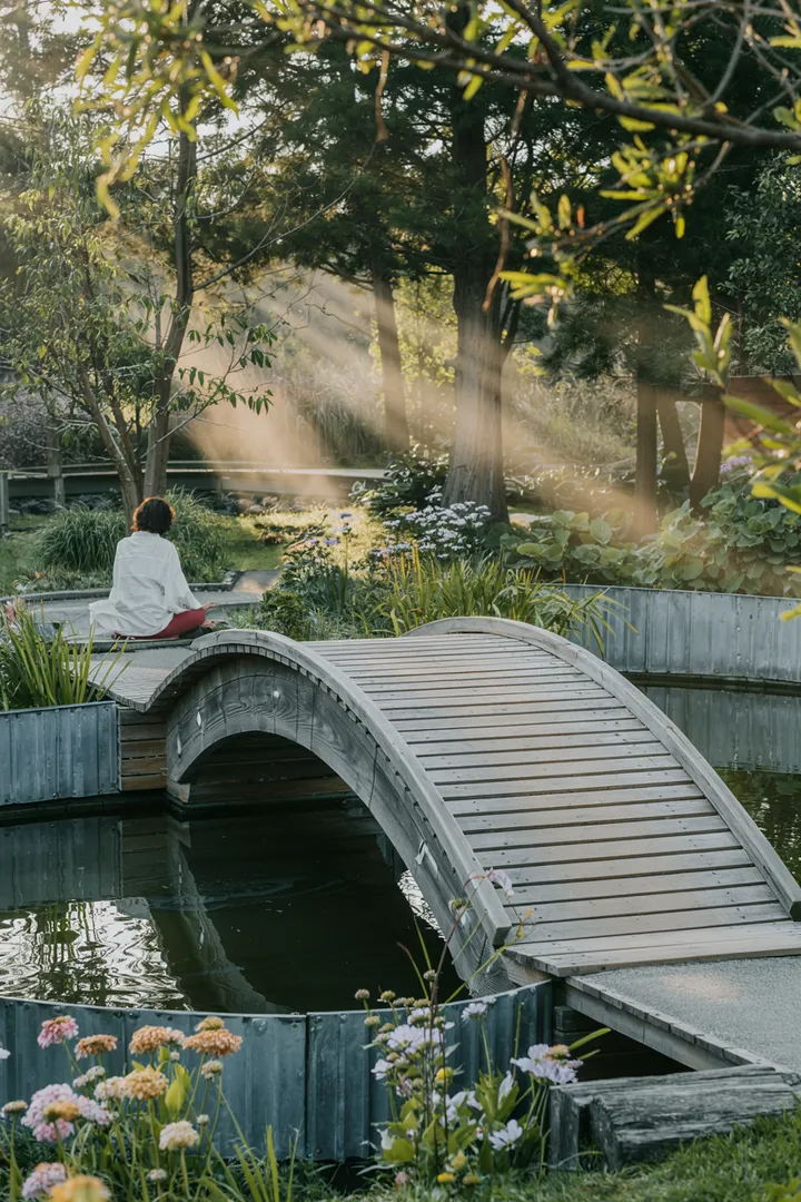 Ein idyllischer Außenbereich mit einem kleinen, wasserfreundlichen Teich in einer Zinkwanne, umgeben von pflegeleichten Pflanzen für einen nachhaltigen Garten.