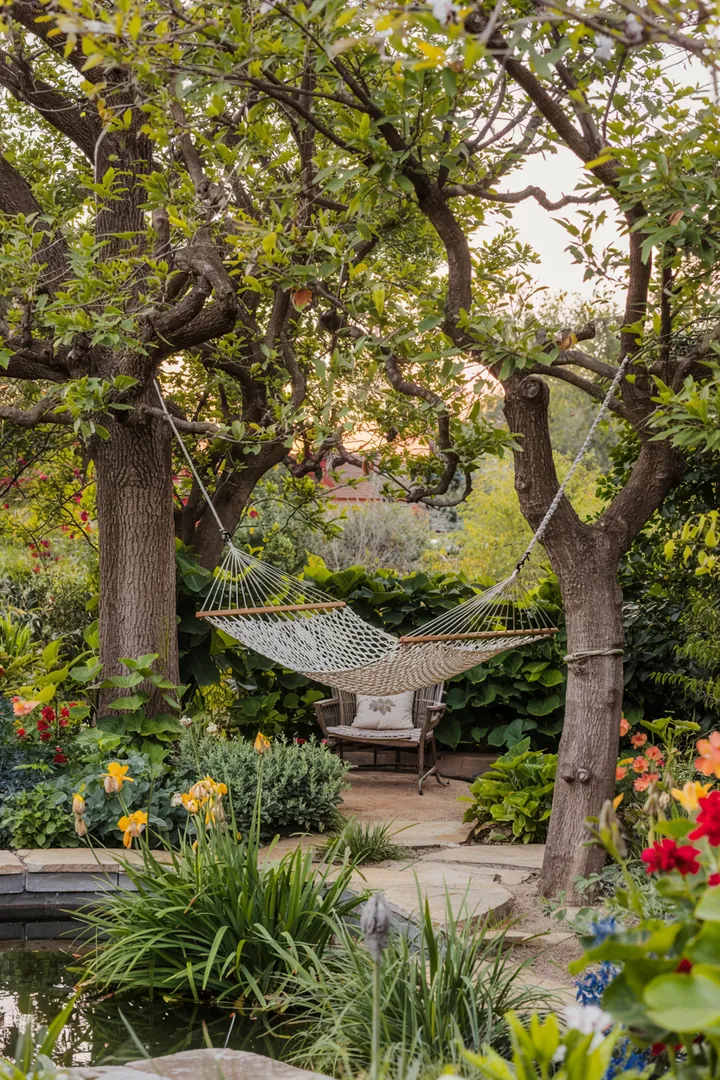 Ein harmonischer Außenbereich mit üppigem Grün, blühenden Pflanzen und einladenden Sitzbereichen, der eine entspannte Atmosphäre für kreative Gartenräume schafft.