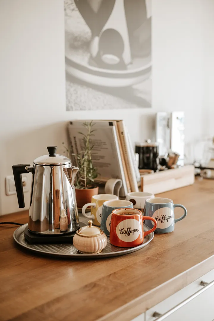 Ein elegantes Küchendesign mit einer stilvollen Espressomaschine auf schlichten Regalen, die eine einladende Atmosphäre schaffen.