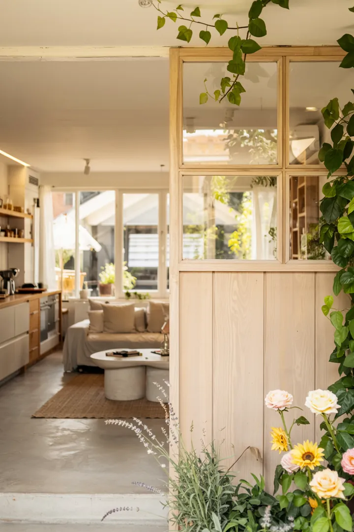 Ein stilvolles Wohnambiente, das eine helle, luftige Kochlandschaft mit einem eleganten Raumteiler und durchdachten Lichtkonzepten kombiniert.