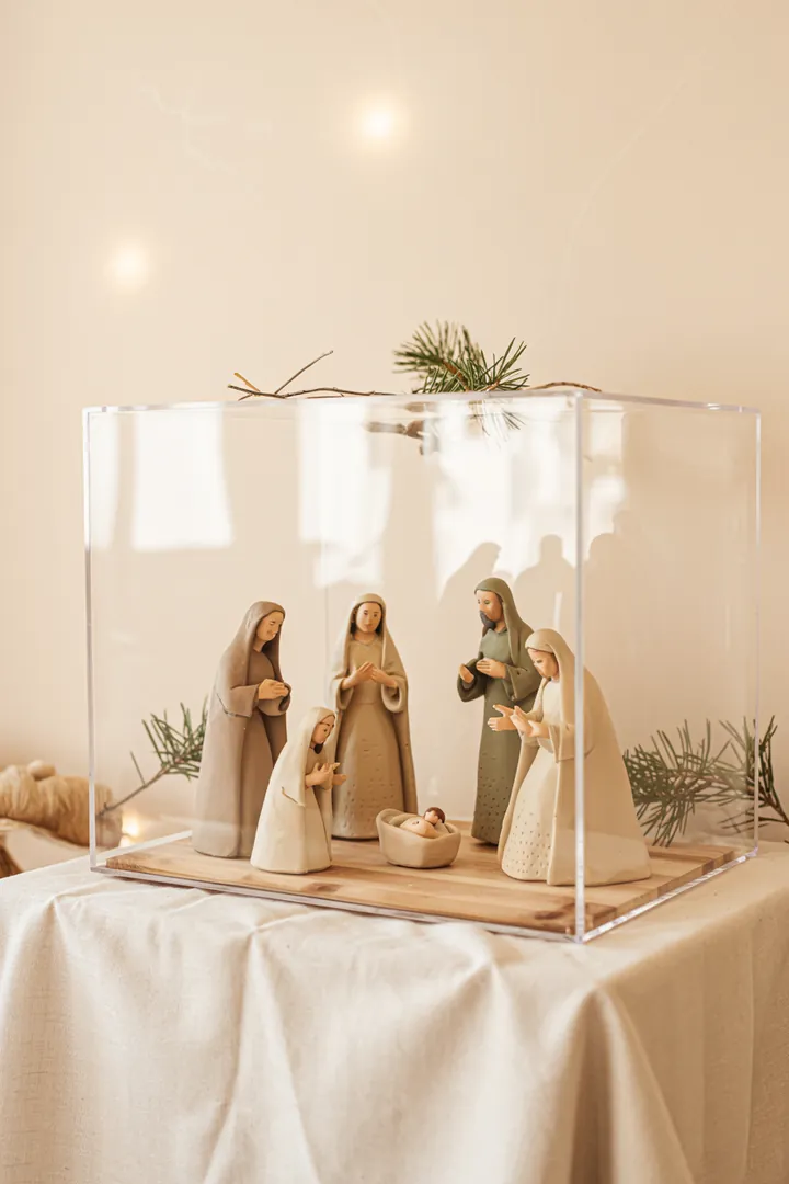 Ein kunstvoll gestaltetes Weihnachtsmotiv zeigt eine handgefertigte Krippe mit leuchtenden Elementen, die das Königskind in der Weihnachtsgeschichte umrahmen.