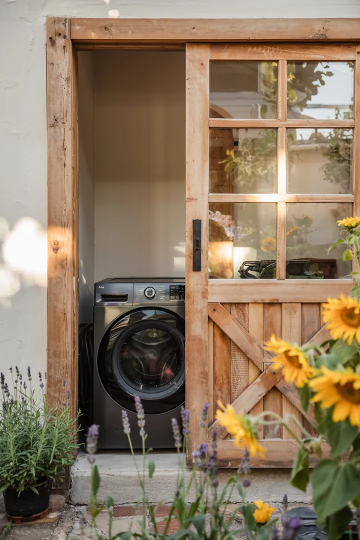 Ein moderner Raum, in dem eine elegante Schiebetür eine Waschmaschine verbirgt, sorgt für Ordnung und Stil in der Wäschepflege.