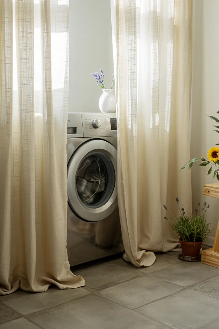 Ein heller Raum mit einem geheimen Blick auf eine moderne Haushaltsmaschine, die hinter einem eleganten Stoff verborgen ist. Ideal für praktische Lösungen im Alltag.