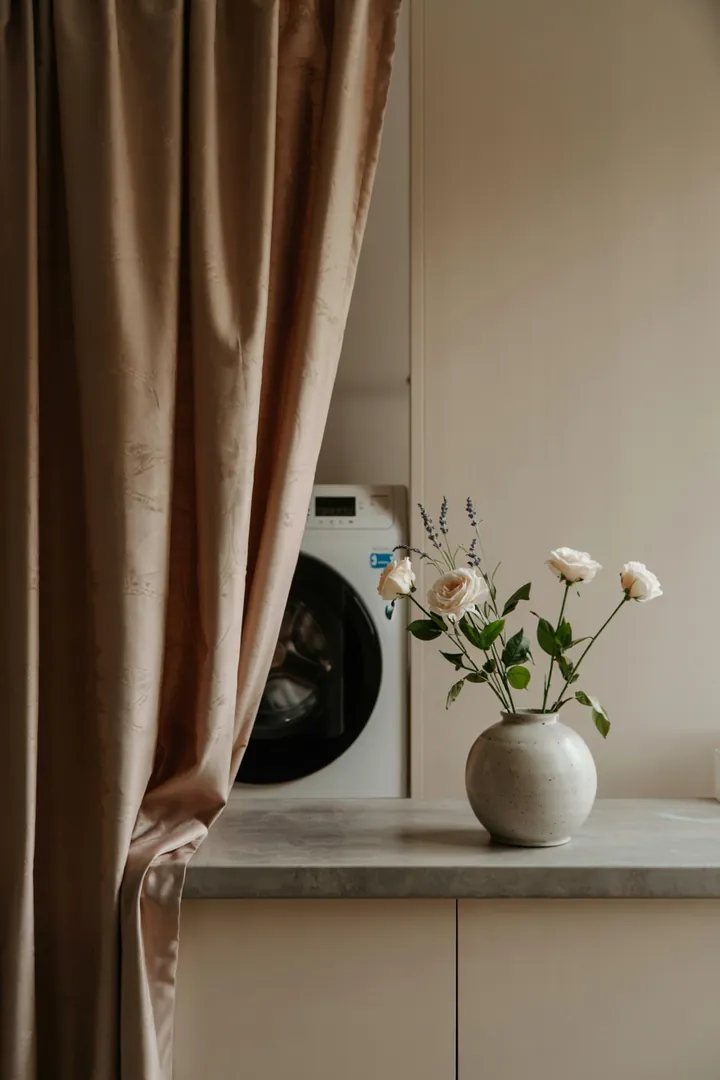 Ein verstecktes Haushaltsgerät hinter einem dekorativen Stoff, das die Funktionalität einer modernen Waschanlage symbolisiert. Ideal für platzsparende Lösungen in der Wohnung.