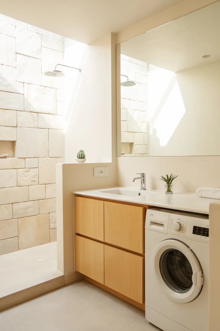 Elegante Gestaltungsidee für ein Badezimmer, in dem moderne Haushaltsgeräte harmonisch in die Raumgestaltung integriert werden, um eine stilvolle und aufgeräumte Atmosphäre zu schaffen.