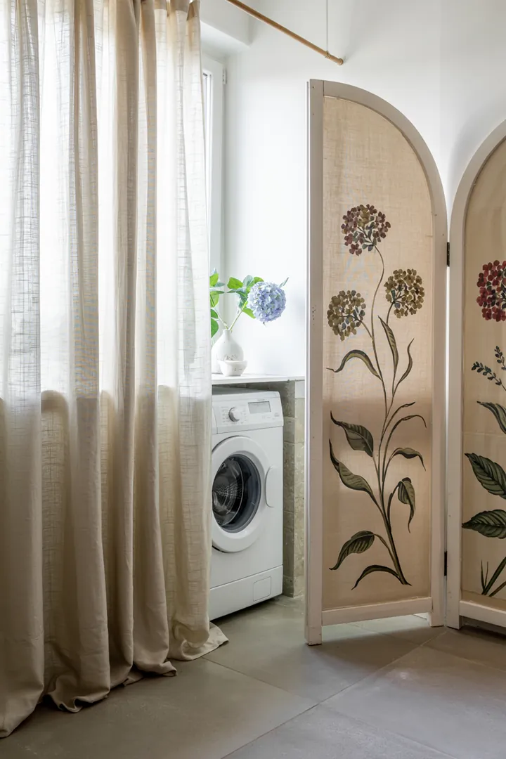 Eine stilvolle Badezimmeransicht, in der eine Haushaltsmaschine durch geschickte Dekoration unauffällig in die Umgebung integriert ist, um den Raum harmonisch wirken zu lassen.