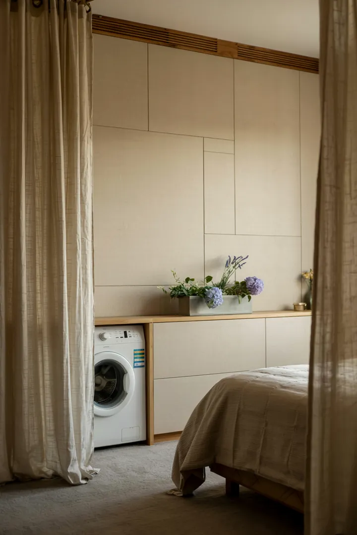 Ein stilvoll gestaltetes Schlafzimmer mit einem cleveren Design, das eine Waschmaschine diskret integriert, sorgt für eine ruhige und harmonische Atmosphäre.