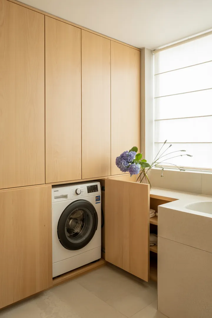 Ein stilvoller Einbauschrank, der eine Waschmaschine geschickt integriert, um den Raum aufgeräumt und funktional zu gestalten.