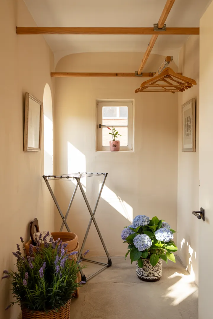 Ein praktischer Stauraum mit einer unauffälligen Waschmaschine, die geschickt in einer kleinen Abstellkammer integriert ist, sorgt für Ordnung und Platzersparnis.