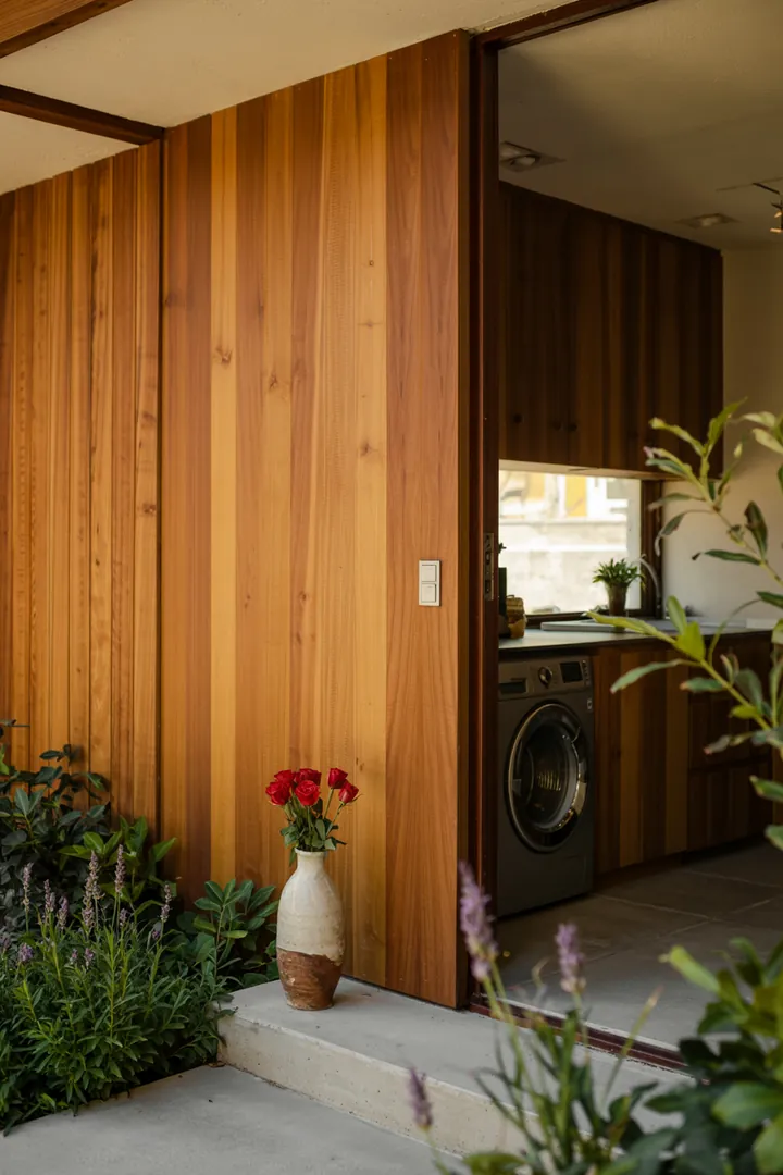 Ein stilvolles Interieur zeigt einen cleveren Stauraum, der eine Haushaltsmaschine diskret in einer modernen Garderobe integriert.