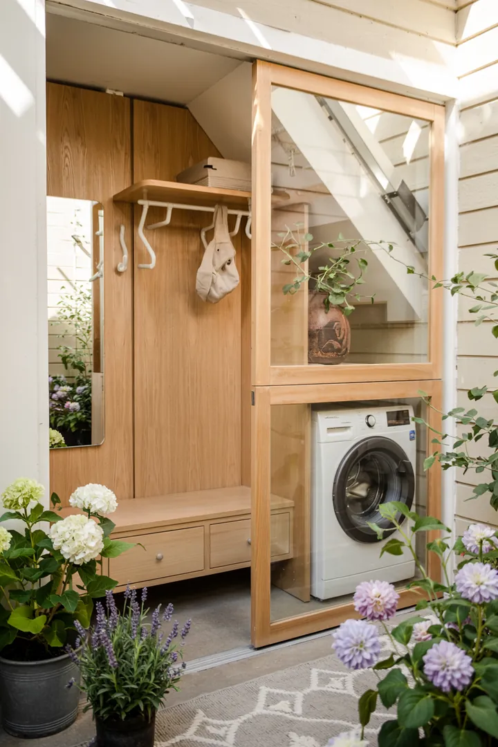 Ein stilvolles Raumdesign zeigt, wie eine Haushaltsmaschine diskret in einem modernen Garderobenschrank integriert ist, um Platz zu sparen und Ordnung zu schaffen.