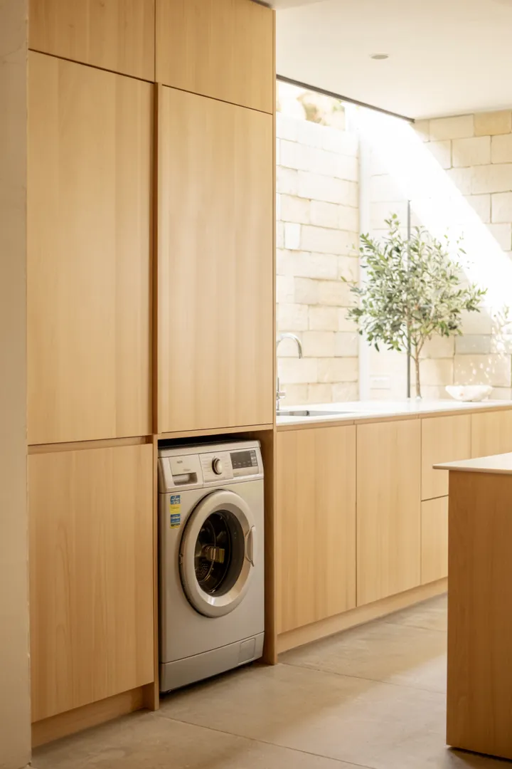 Ein stilvolles Wohnambiente mit einer clever integrierten Haushaltslösung, die eine praktische Geräteaufbewahrung in einem modernen Raum bietet.