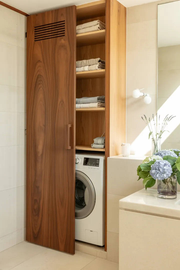 Praktische Lösung für die versteckte Haushaltswäsche: Eine Möbeltür kaschiert geschickt das Gerät und integriert es harmonisch ins Wohnambiente.