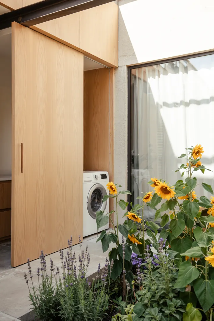 Eine stilvolle Lösung, um Haushaltsgeräte diskret in die Küchenumgebung zu integrieren, indem eine Möbeltür vor der Maschine angebracht wird.