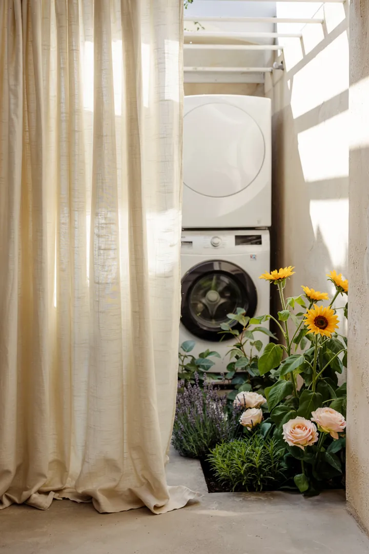 Ein innovativer Möbelstück, das eine Waschmaschine und einen Trockner in einem stilvollen Turm kombiniert, um Platz zu sparen und die Laundry-Ecke modern zu gestalten.