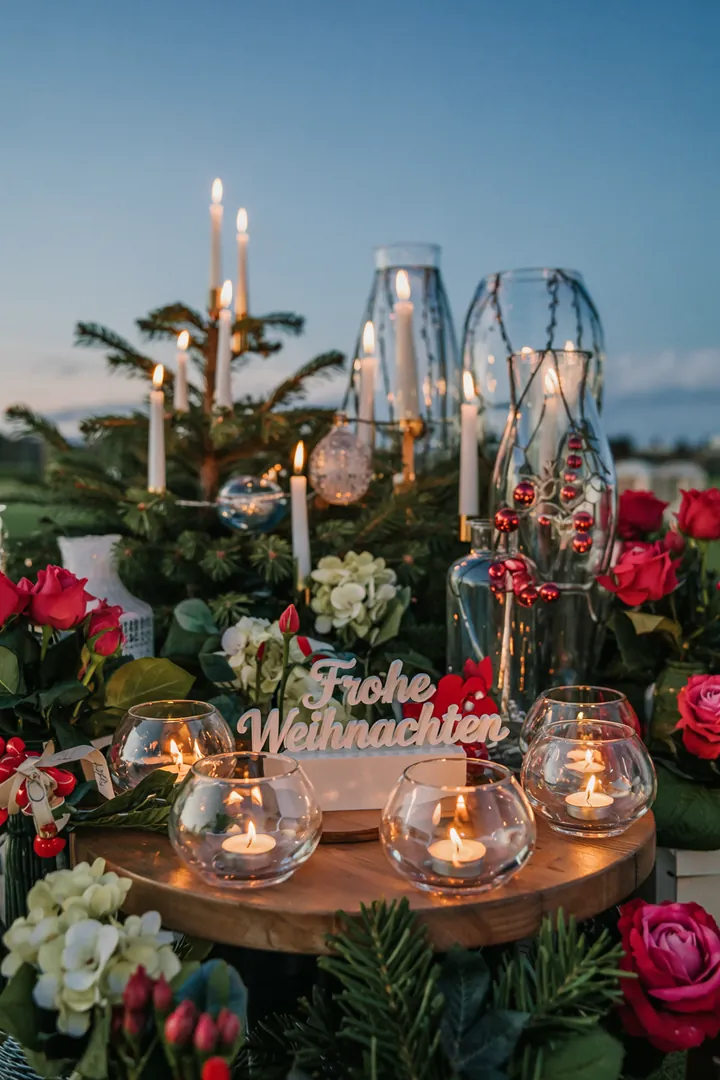Ein festlich dekoriertes Glas mit schimmerndem Licht, umgeben von Tannenzweigen und winterlichen Akzenten, ideal für die Adventszeit.